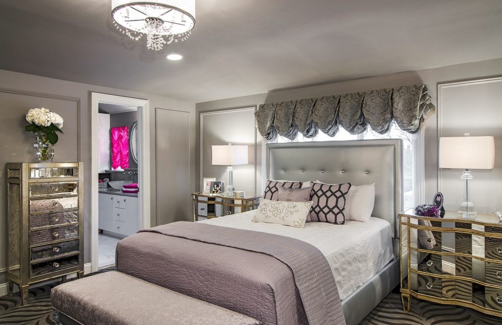 Bedroom with bed with grey bedframe, mirrored nightstands and mirrored dresser