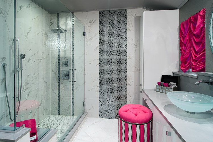Bathroom with large glass shower, vanity with vessel sink and pink pops of color