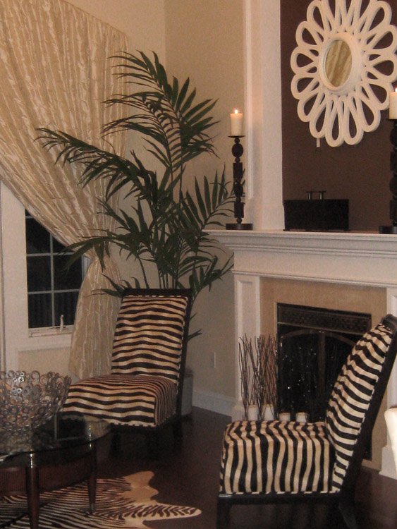 Two zebra patterned chairs in front of a fireplace