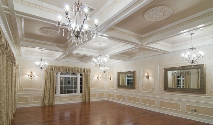 Ballroom with wall moldings, coffered ceiling with medallions, wood floor, picture window and chandelier